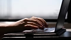 سيدة تكتب على كمبيوتر محمول في قطار في ولاية نيو جيرسي، الولايات المتحدة الأمريكية.