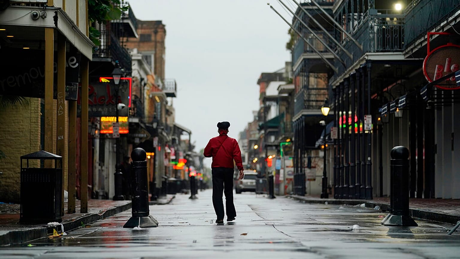 A man walks down a mostly deserted Bourbon Street in the French Quarter as the early effects of Hurricane Ida are felt, Sunday, Aug. 29, 2021, in New Orleans, La. 