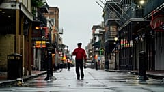 A man walks down a mostly deserted Bourbon Street in the French Quarter as the early effects of Hurricane Ida are felt, Sunday, Aug. 29, 2021, in New Orleans, La. 