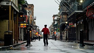 A man walks down a mostly deserted Bourbon Street in the French Quarter as the early effects of Hurricane Ida are felt, Sunday, Aug. 29, 2021, in New Orleans, La.