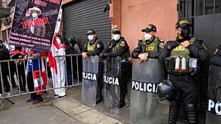 Un detractor de Pedro Castillo porta una pancarta augurando hambre y miseria para Perú durante una protesta frente al Congreso