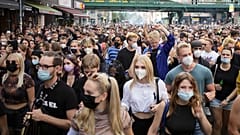 People, most of them wearing masks, dance behind a truck as they attend a demonstration named 'Train of Love' in Berlin, Germany, Saturday, Aug. 28, 2021
