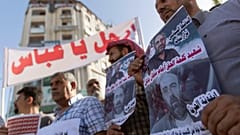 فلسطينيون يقفون بمدينة رام الله يرفعون لافتات تندد بمقتل الناشط نزار بنات على أيدي عناصر من الأجهزة الأمنية الفلسطينية. 03/07/2021