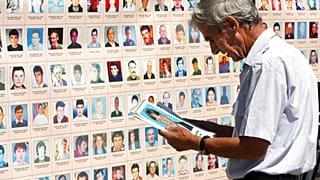 مواطن ألباني يتصفح صور الأشخاص المفقودين في حرب كوسوفو 1998-1999 خارج مبنى حكومي في بريشتينا، السبت 28 أغسطس/آب 2010.