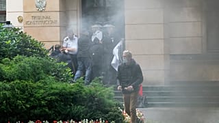 A group of pro-democracy activists in Poland seek to bloc the entrance of the constitutional court in an act of civil disobedience in Warsaw, Poland, on Monday Aug. 30, 2021