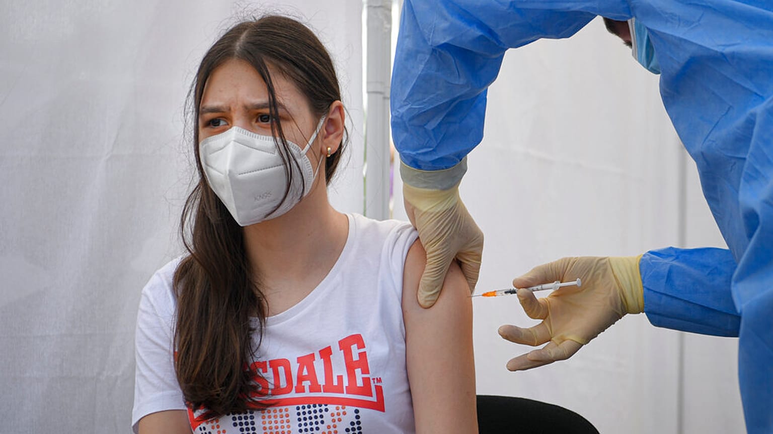 A girl gets a Pfizer BioNTech COVID-19 vaccine in Bucharest