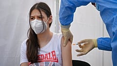 A girl gets a Pfizer BioNTech COVID-19 vaccine in Bucharest