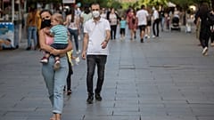Pedestrians wear face masks through Mother Teresa square in Kosovo's capital Pristina.