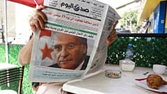 رجل يقرأ صحيفة تتصدر عناوينها اعتقال المرشح الرئاسي التونسي السابق نبيل القروي الثلاثاء 31 أغسطس 2021 في الجزائر 