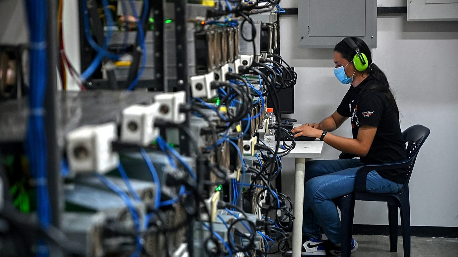 An employee inspects computers used to mine Bitcoin at the mining showroom of the Doctor Miner company in Caracas on August 18, 2021. 