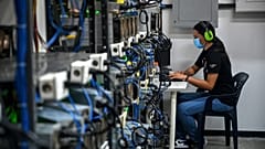 An employee inspects computers used to mine Bitcoin at the mining showroom of the Doctor Miner company in Caracas on August 18, 2021. 