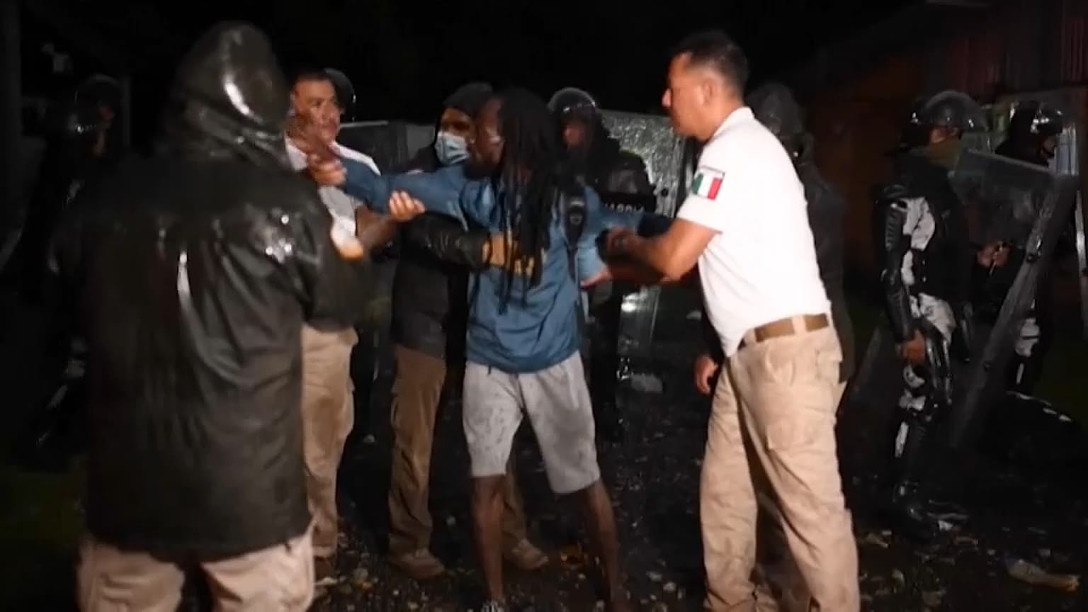 Agentes del Instituto Nacional de Migraciones detienen a un migrante haitiano