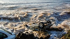 Coches arrastrados hasta el mar en la localidad costera de Alcanar, en el noreste de España 