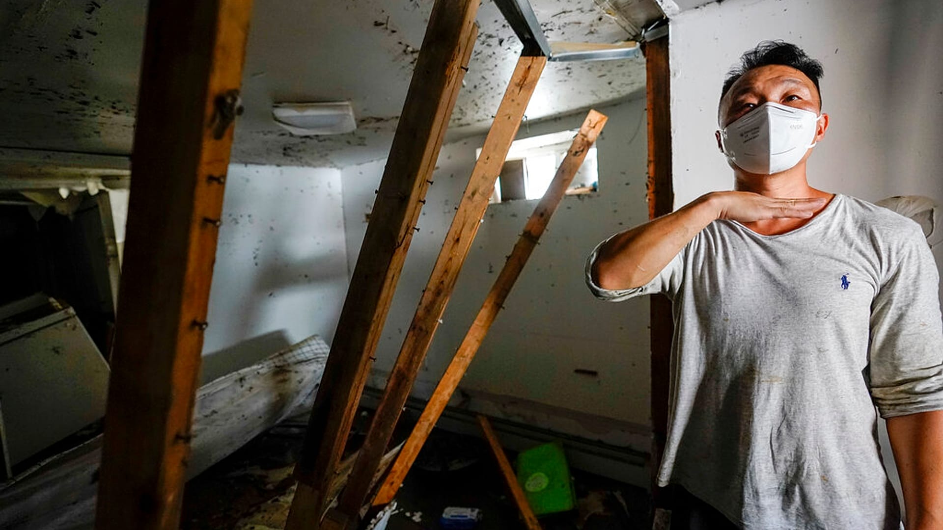 Danny Hong shows where the water reached up to him as he shows the damage in his basement apartment on 153rd St. in the Flushing neighborhood of the Queens borough of New York