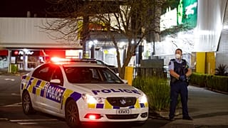 Police stand outside the site of a knife attack at a supermarket in Auckland.