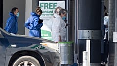 Police forensic staff stand outside a supermarket in Auckland, New Zealand, Saturday, Sept. 4, 2021. 