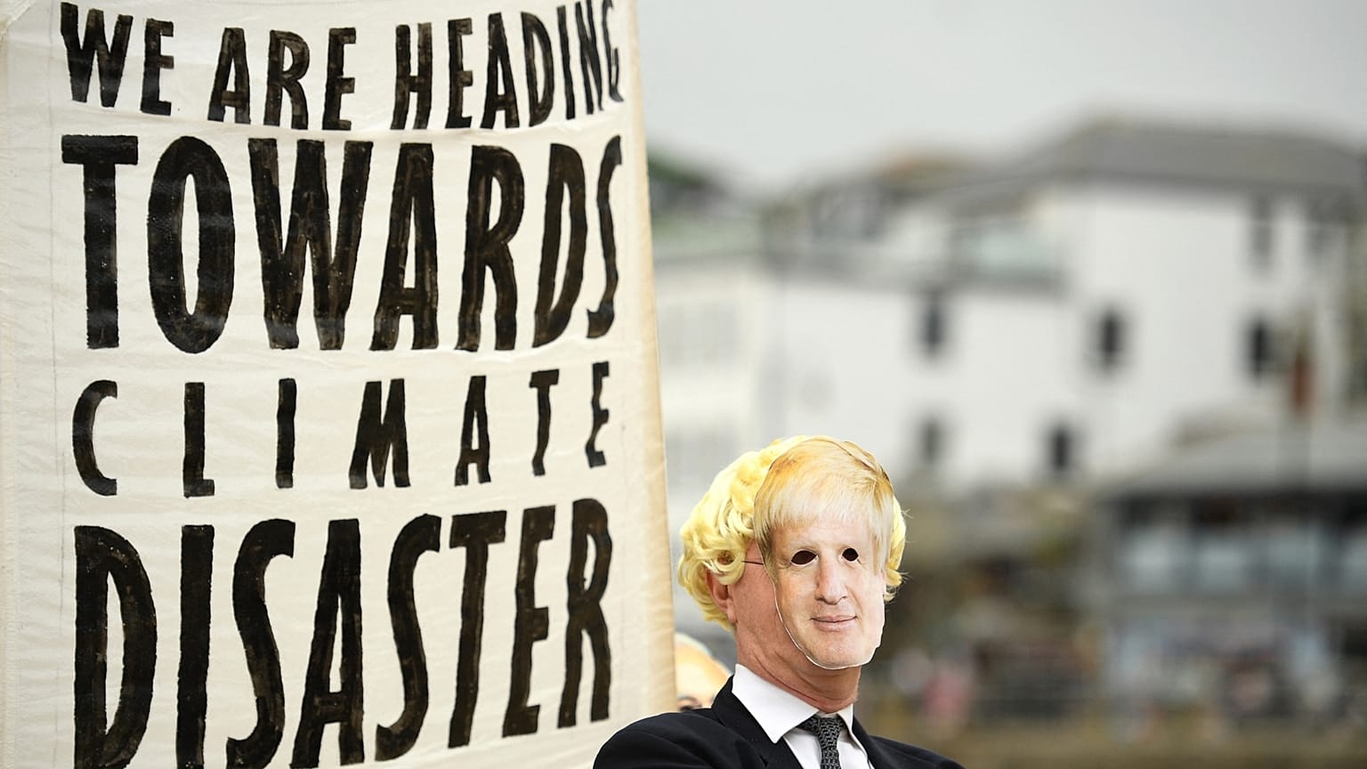 Environmental activist wears a face masks of Britain's Prime Minister Boris Johnson at the G7 summit earlier this year. 