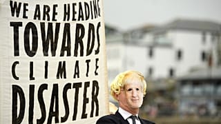 Environmental activist wears a face masks of Britain's Prime Minister Boris Johnson at the G7 summit earlier this year.