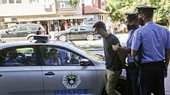 Kosovo police officers arrest an activist for spray painting on a vehicle transporting Kosovo Specialist Chamber court President Ekaterina Trendafilova, Pristina, Sept.7, 2021