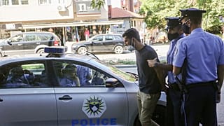 Kosovo police officers arrest an activist for spray painting on a vehicle transporting Kosovo Specialist Chamber court President Ekaterina Trendafilova, Pristina, Sept.7, 2021