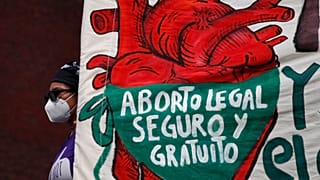 In this Sept. 28, 2020 file photo, a woman holds a banner reading: "legal, safe, and free abortion" in Mexico City.