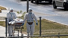 medical workers carry a patient suspected of having coronavirus at a hospital in Kommunarka, outside Moscow, Russia, June 26, 2021.