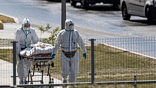 medical workers carry a patient suspected of having coronavirus at a hospital in Kommunarka, outside Moscow, Russia, June 26, 2021.
