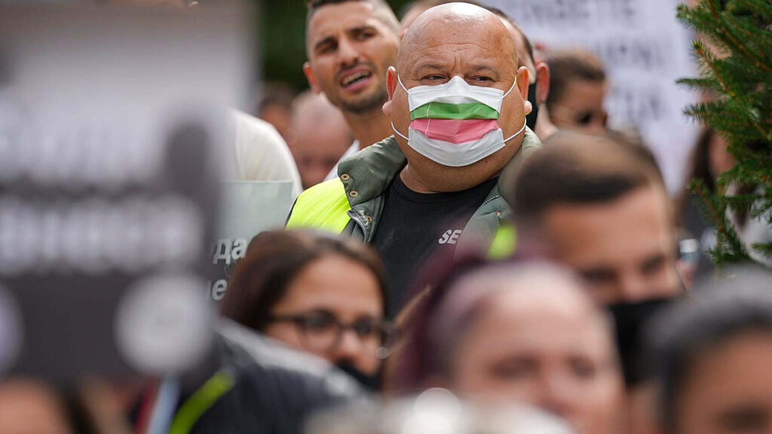A man wears a mask in the colors of the Bulgarian flag while attending a protest by restaurant workers in Veliko Tarnovo, Bulgaria, Thursday, Sept. 2