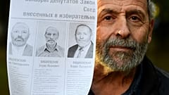 Boris (Lazarevich) Vishnevsky holds a photocopy of a poster with candidates running for election to the regional parliament in Saint Petersburg. 