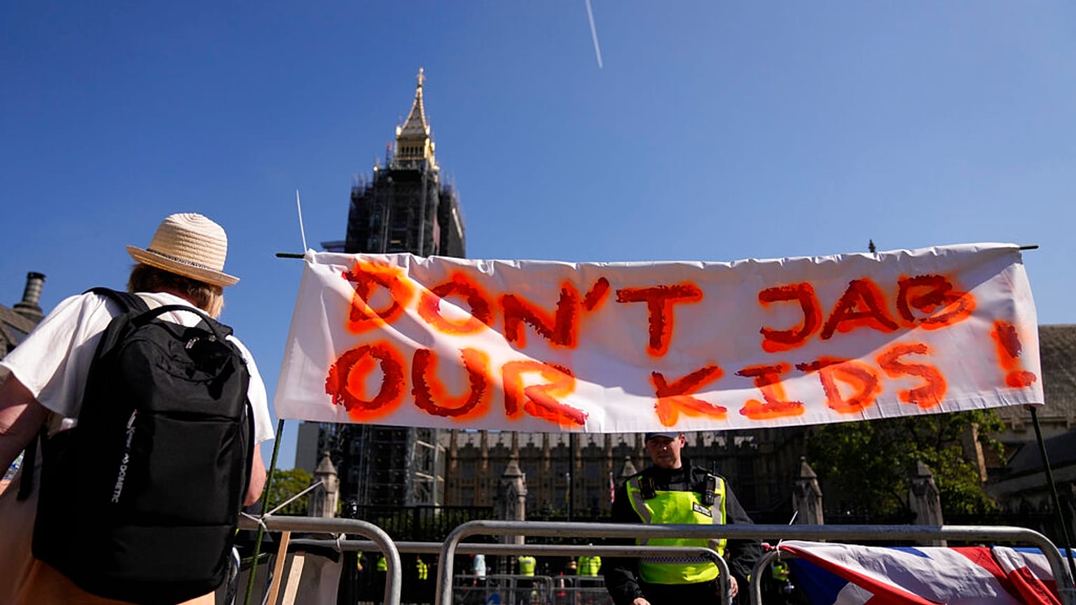 Uno striscione contro la somministrazione di vaccini contro il coronavirus ai bambini viene visualizzato durante una protesta in Parliament Square di fronte alle Houses of Par