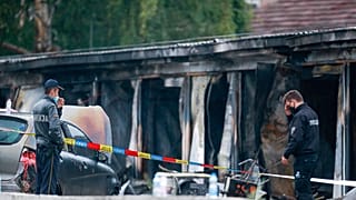 Police officers and forensics investigate the site at a burned out makeshift hospital after a fire in North Macedonia's northwestern city of Tetovo, early Thursday, Sept. 9, 2
