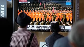 People watch a TV showing a military parade held in Pyongyang, North Korea, at Seoul Railway Station in Seoul, South Korea, Thursday, Sept. 9, 2021.