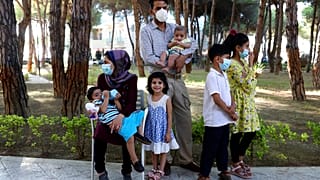 An Afghan family gather at a resort which is accommodated Afghan refugees in Golem, west of the capital Tirana.