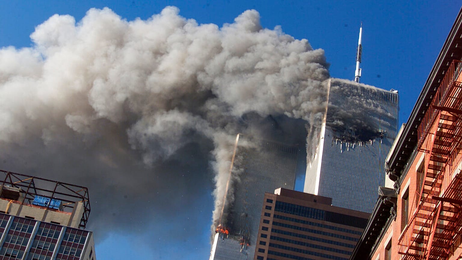 Rauch steigt von den brennenden Zwillingstürmen des World Trade Centers in New York City auf, nachdem entführte Flugzeuge in die Türme gestürzt waren. 11. September 2001.