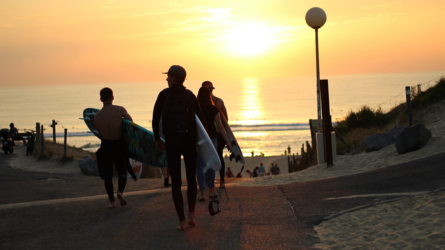 The sun sets over surfers in Hossegor, France. 