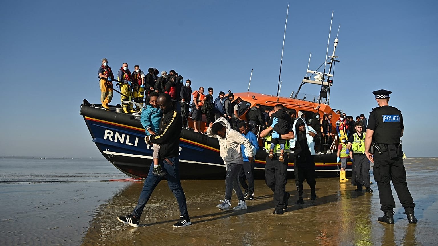 Migrants are escorted after being picked up by an RNLI (Royal National Lifeboat Institution) lifeboat while crossing the English channel, Dungeness, September 7, 2021.England