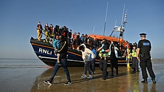 Migrants are escorted after being picked up by an RNLI (Royal National Lifeboat Institution) lifeboat while crossing the English channel, Dungeness, September 7, 2021.England