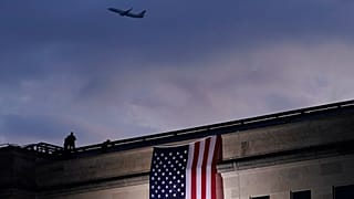 Foto de archivo: un avión despega del Aeropuerto Nacional Reagan de Washington mientras se despliega una gran bandera estadounidense en el Pentágono.