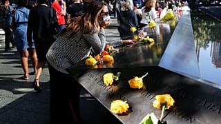 Une femme se recueille au mémorial du 11 septembre à New York lors de la cérémonie du 20ème anniversaire des attentats, New York le 11 septembre 2021