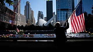 Az Egyesült Államok lobogóját tartja Germano Rivera a New York-i Ground Zero emlékműnél 2021. szeptember 11-én