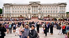 Members of the public watch the Changing of the Guard ceremony at Buckingham Palace, London, Monday August 23, 2021