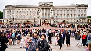 Members of the public watch the Changing of the Guard ceremony at Buckingham Palace, London, Monday August 23, 2021