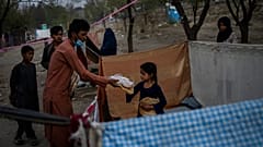 Displaced Afghans distribute food donations at an internally displaced persons camp in Kabul, Afghanistan, Monday, Sept. 13, 2021. 