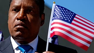 Larry Elder, locutor de radio y aspirante a gobernador de California, sostiene una bandera de Estados Unidos durante un mitin de campaña