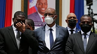 Haiti's Prime Minister Ariel Henry (C) in front of a portrait of slain Haitian President Jovenel Moise at the National Pantheon Museum Port-au-Prince, Haiti, July 20, 2021.