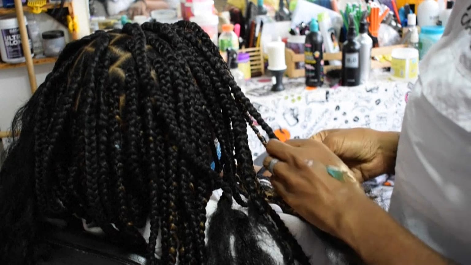 Estilista venezolana trenzando pelo afro, 17/08, 2021, Caracas, Venezuela