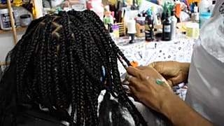 Estilista venezolana trenzando pelo afro, 17/08, 2021, Caracas, Venezuela