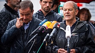 In this Tuesday, Aug.3, 2021 file photo Armin Laschet and Olaf Scholz ddress the media during a press conference in Stolberg, Germany that was hit by heavy rain and floods.