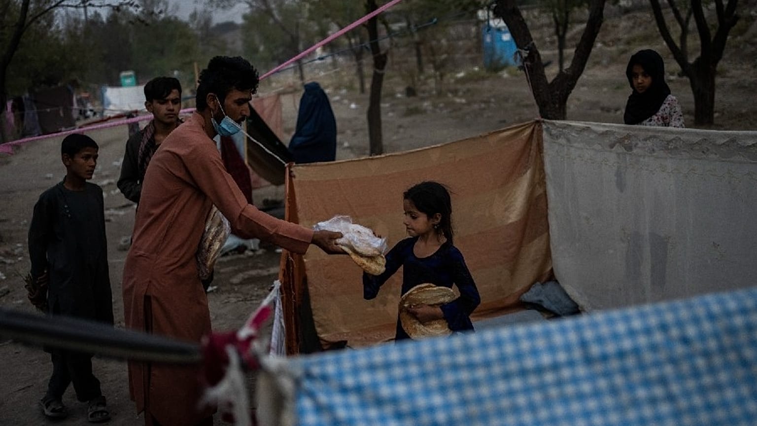 Displaced Afghans distribute food donations at an internally displaced persons camp in Kabul, Afghanistan, Monday, Sept. 13, 2021.