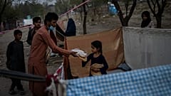 Displaced Afghans distribute food donations at an internally displaced persons camp in Kabul, Afghanistan, Monday, Sept. 13, 2021.